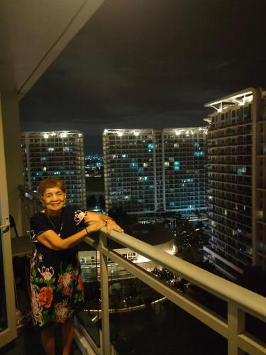 a woman standing on the balcony of a skyscraper at Azure staycation by marco in Manila
