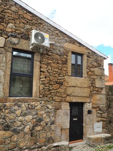 a stone building with a window and a speaker at Casa da Ti Paqueta in Sabugal