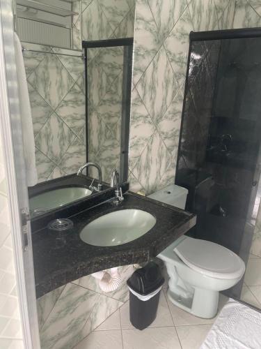 a bathroom with a sink and a toilet at Hotel Shalom in Juazeiro do Norte