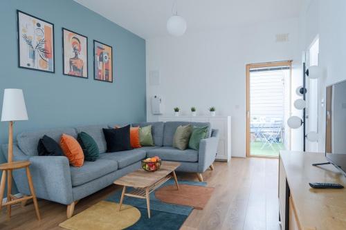 a living room with a blue couch and a table at Modern 2-Bed Apartment Near ExCeL & O2 - Accommodates up to 4 Guests Max in London