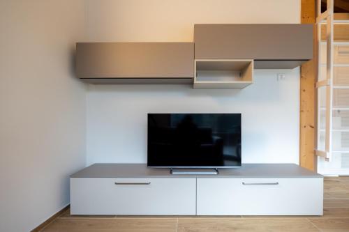 a flat screen tv sitting on top of a white entertainment center at Apartments and holidays Cav Chiara Tione di Trento in Tione di Trento