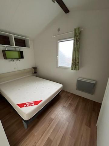 une petite pièce avec un lit et une fenêtre dans l'établissement Mobile home 6 personnes 1semaine minimum juillet août, à Saint-Hilaire-de-Riez