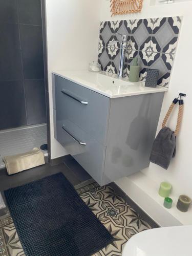 a bathroom with a sink and a toilet and a rug at Appartement au gré des bulles in Cucq