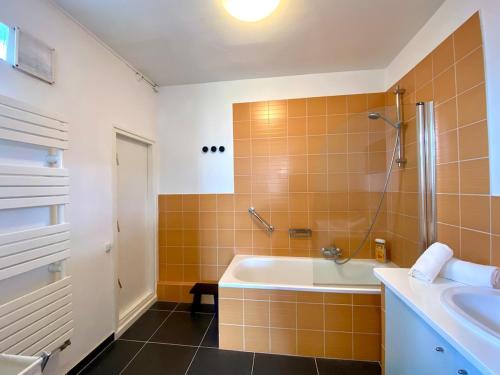a bathroom with a tub and a sink at Villa La Smalah, familiale 6 chambres- vue Mer - jacuzzi - wifi - tout confort in Ault