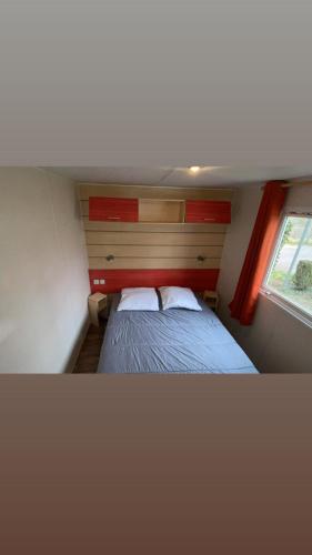 une petite chambre avec un lit et une fenêtre dans l'établissement Camping le ried B021 et N038, à Boofzheim