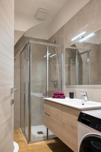 a bathroom with a shower and a white sink at Apartments and holidays Cav Chiara Tione di Trento in Tione di Trento