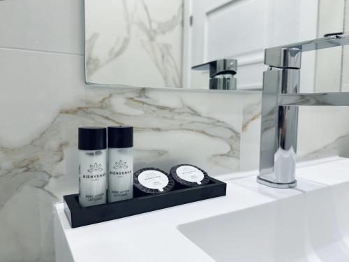 a bathroom with a sink with two products on a counter at Hotel Apartamentos Marina Luz in Chipiona
