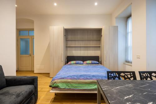 a bedroom with a bed and a couch and a table at Apartments and holidays Cav Chiara Tione di Trento in Tione di Trento