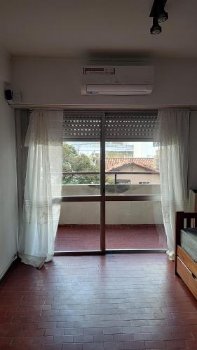 Cette chambre dispose d'une grande porte en verre et d'une fenêtre. dans l'établissement Luminoso departamento Zona Güemes, à Mar del Plata