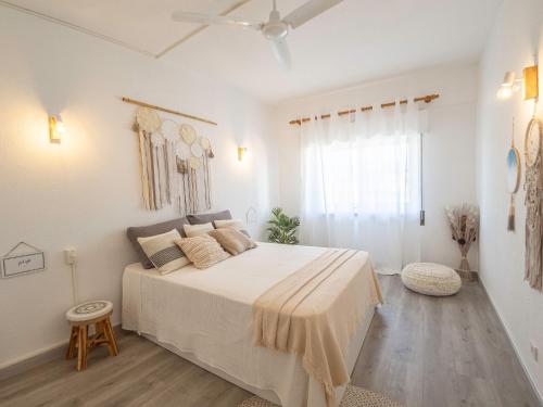 a white bedroom with a large bed and a window at Boho house, Albufeira in Albufeira