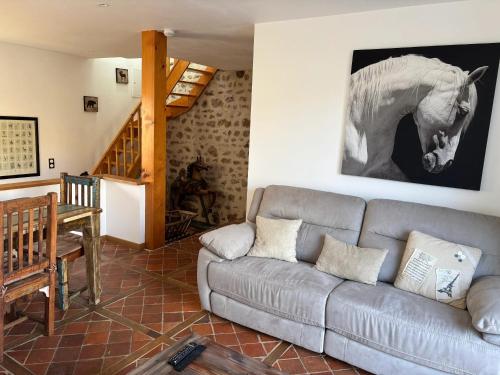 a living room with a couch and a horse picture on the wall at Maison charmante au cœur d'Alligny-en-Morvan avec vue in Alligny-en-Morvan