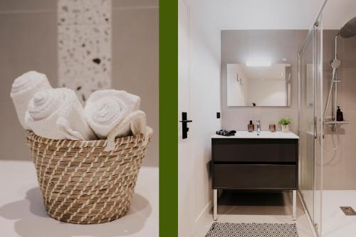 La salle de bains est pourvue d'un lavabo et d'un panier avec des serviettes. dans l'établissement Appartement hypercentre Jean Jaurès, Parking privé, Ascenseurs, à Toulouse