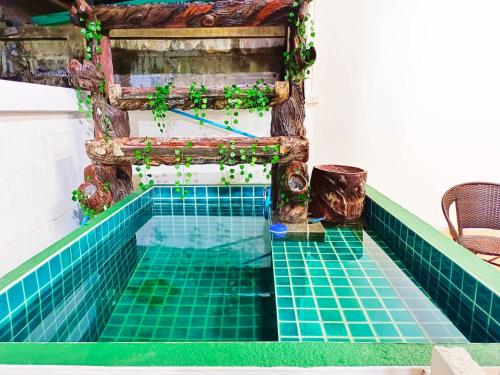 a pool in a house with green tiled floors at Sukhumvit 81 Haven House- BTS Onnut in Bangkok