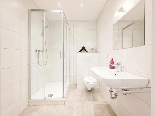 a bathroom with a shower and a sink and a toilet at Tolstov Apartments - 3 Room Apartment - Kitchen - Dining Area - 25 min Messe DUS in Duisburg