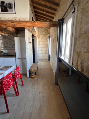 a kitchen with a table and red chairs in a room at Lou Mirèio in Aigues-Mortes