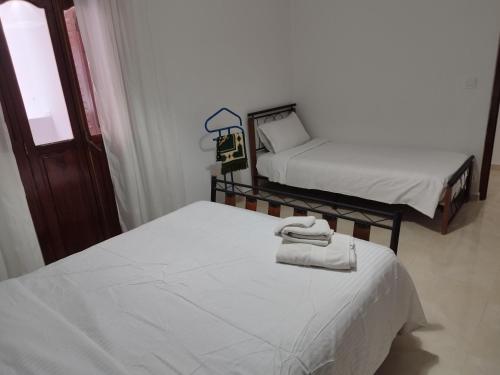 a room with two beds with towels on them at Dar Mifa in Martil