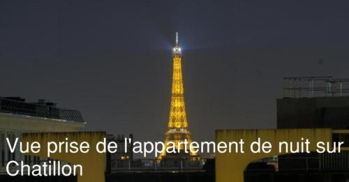 une tour éclairée avec un panneau devant elle dans l'établissement Chambre chez l'habitant Chatillon dans appartement partagé avec d'autres visiteurs et espace journée, à Châtillon