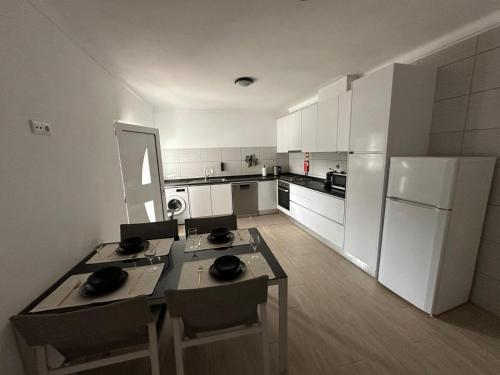 una cucina con un tavolo e un frigorifero bianco di Casa da vinha a Anreade