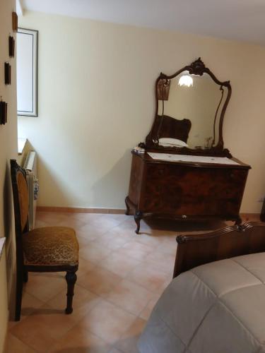 a bedroom with a dresser with a mirror and a chair at la quiete in Arpino