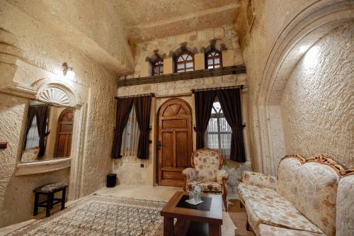 a living room with a couch and a wooden door at Kemerhan Cave Suites in Urgup