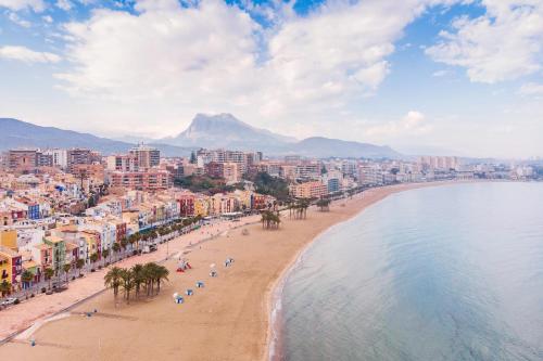 a view of a beach with a city and the ocean at Kiboko Beach in Villajoyosa