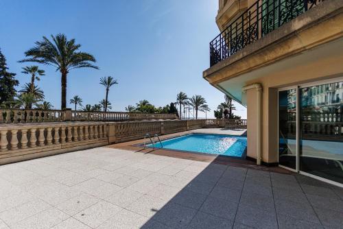 une piscine devant un immeuble dans l'établissement Le Victoria, élégant T2 au bord des plages, piscine, sauna, à Menton