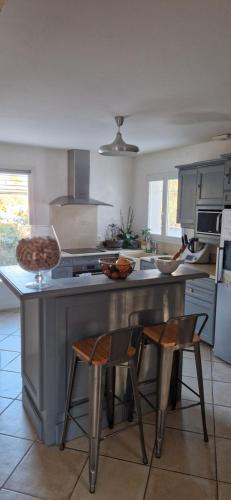 - une cuisine avec un comptoir et 2 chaises dans l'établissement Spacieuse villa 4 chambres, à Saint-Maximin-la-Sainte-Baume