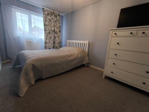 a bedroom with a bed and a dresser and a window at Spotless and Spacious Manchester Home in Manchester