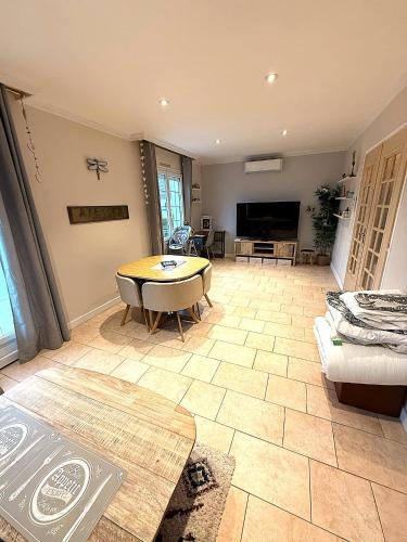 a living room with a table and a couch at Les mésanges, 10m Zoo de Beauval, climatisation in Noyers-sur-Cher