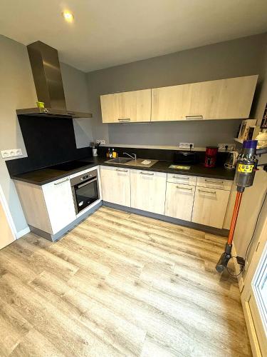 une cuisine avec des armoires blanches et un plancher en bois dans l'établissement Les mésanges, 10m Zoo de Beauval, climatisation, à Noyers-sur-Cher