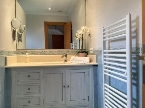 a bathroom with a sink and a mirror at Cerca de Santander La Llosa de Muriedas en Urbanización in Camargo