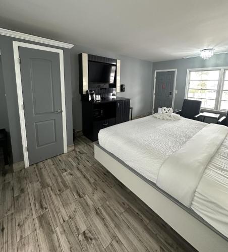 a bedroom with a large white bed and a desk at Historic Waterfront Marion Motor Lodge in downtown St Augustine in Saint Augustine