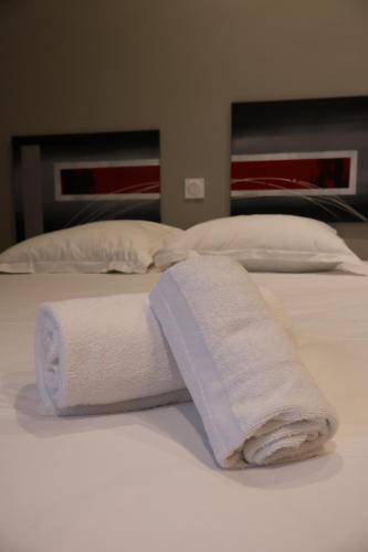 two towels are sitting on top of a bed at Domaine La Grande Bruyère in Touffréville