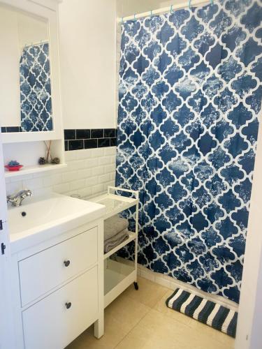 une salle de bain avec un lavabo et un rideau de douche dans l'établissement T1 proche de Genève - Parking, zone calme et bien desservie - belle vue, à Annemasse