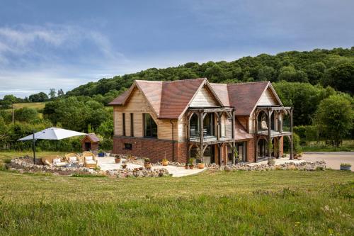 a large brick house with a roof at Woodlands Malvern B and B in Longley Green