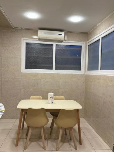 a dining room table with chairs and a air conditioner at Le cozy du plein centre in Oran
