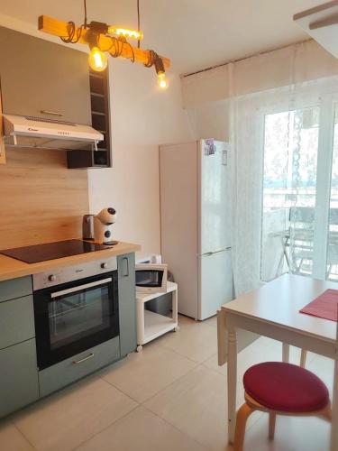 une cuisine avec une cuisinière et une table à l'intérieur dans l'établissement T1 proche de Genève - Parking, zone calme et bien desservie - belle vue, à Annemasse