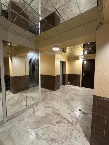 an empty room with marble floors and a glass wall at Kvartira in Tbilisi City