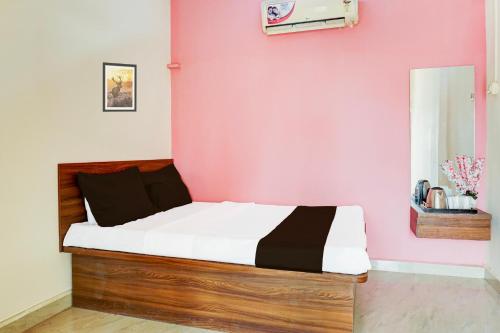 - un lit dans une chambre avec un mur rose dans l'établissement Hotel O Samruddhi Executive Lodge, à Pune