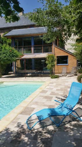 une chaise bleue assise à côté d'une piscine dans l'établissement La Maison aux Volets Bleus, à Saint-Clément