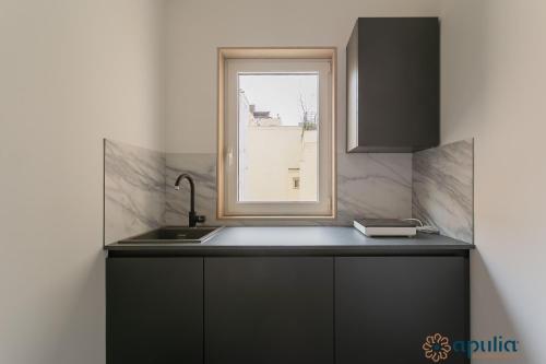 a kitchen with a sink and a window at Palazzo Piccinni 97 by Apulia Accommodation in Bari