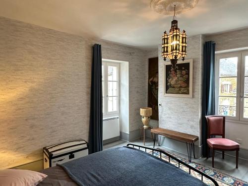 une chambre avec un lit et un lustre dans l'établissement Maison de Laurent, à Saints