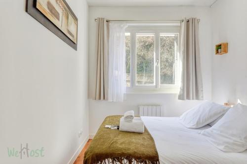 une chambre blanche avec un lit et une fenêtre dans l'établissement T3 étoilé Meuble de tourisme, à Lyon