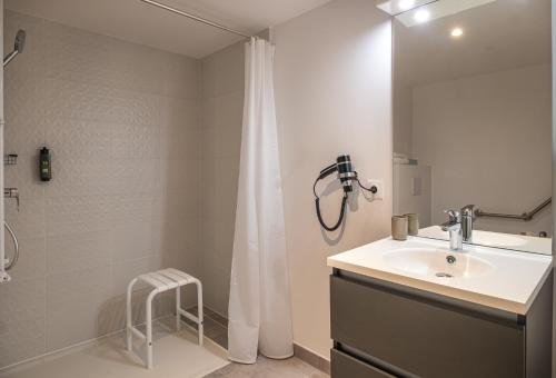 a white bathroom with a sink and a shower at The Originals Résidence Paris Sud Villejuif in Villejuif
