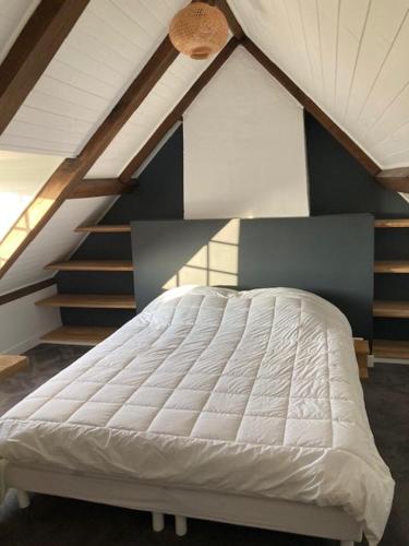 - un lit blanc dans une chambre avec un escalier dans l'établissement Gite Mer & Vallons à proximité plage des Grands Sables, à Locmaria