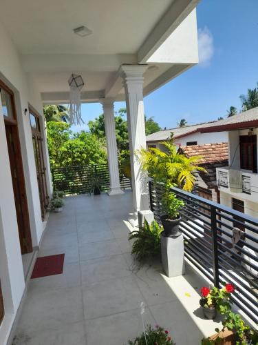 a porch of a house with columns and plants at Villa KN in Ambalangoda