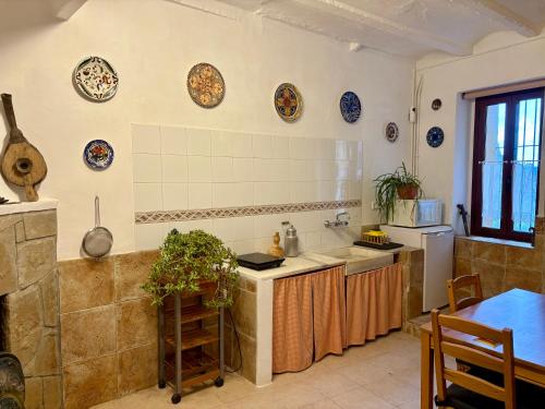 a kitchen with plates on the wall and a table at Casa Añeja in Collbató