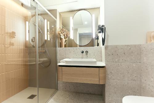 a bathroom with a sink and a shower at Golden Hour Apartments- Loft H 302 in Świnoujście