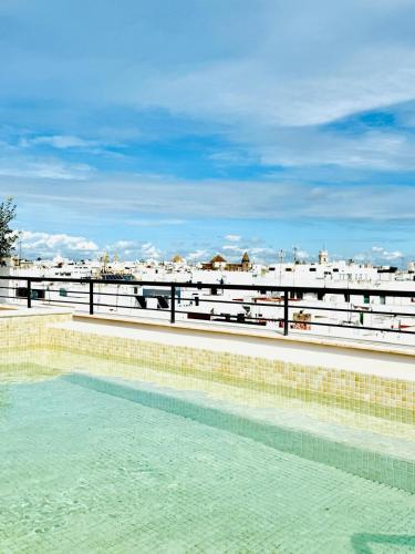 a swimming pool with a view of the beach at La Caleta QE Hotels in Cádiz