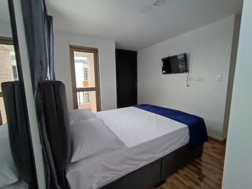 a bedroom with a bed with a tv on the wall at Apartahotel JDK in Armenia
